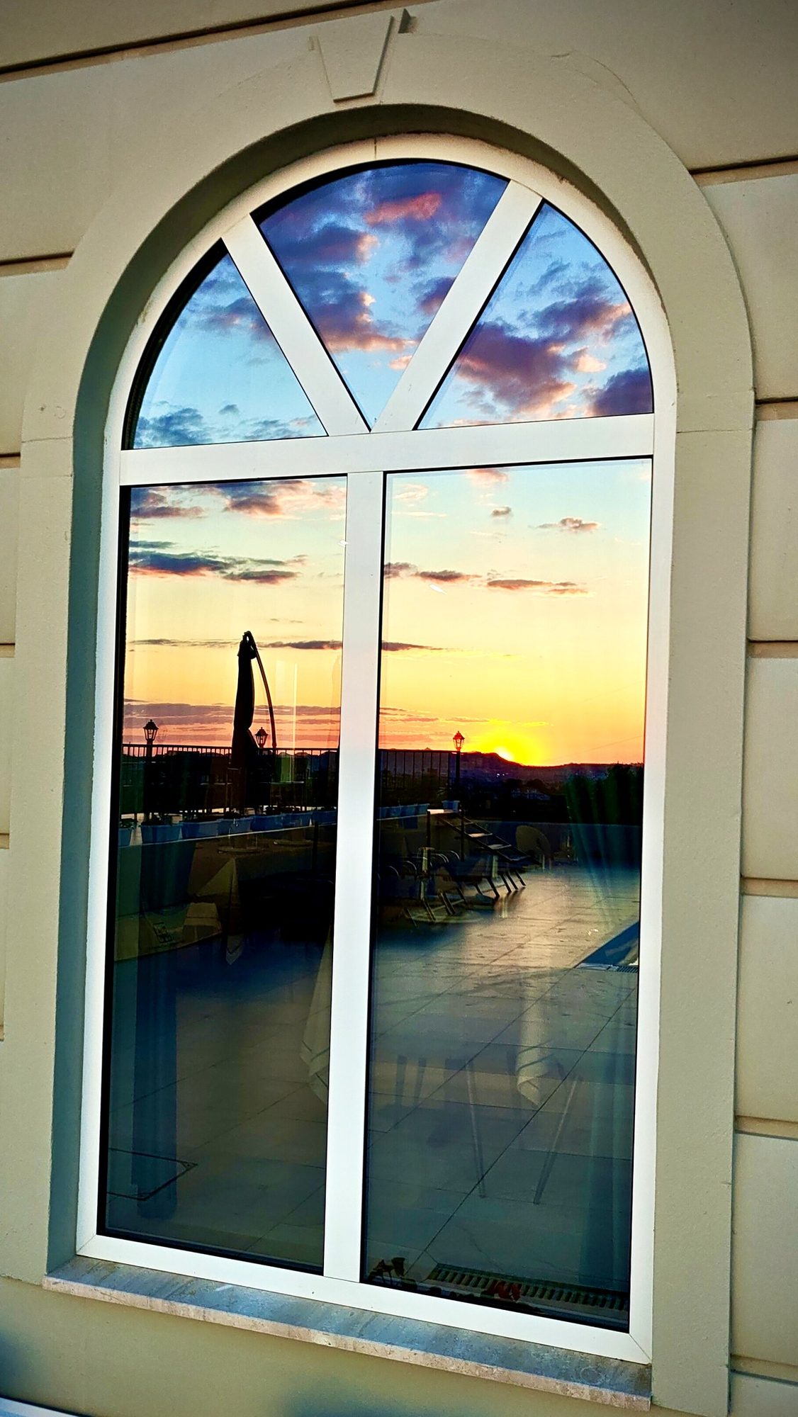 Finestra ad arco — tramonto riflesso